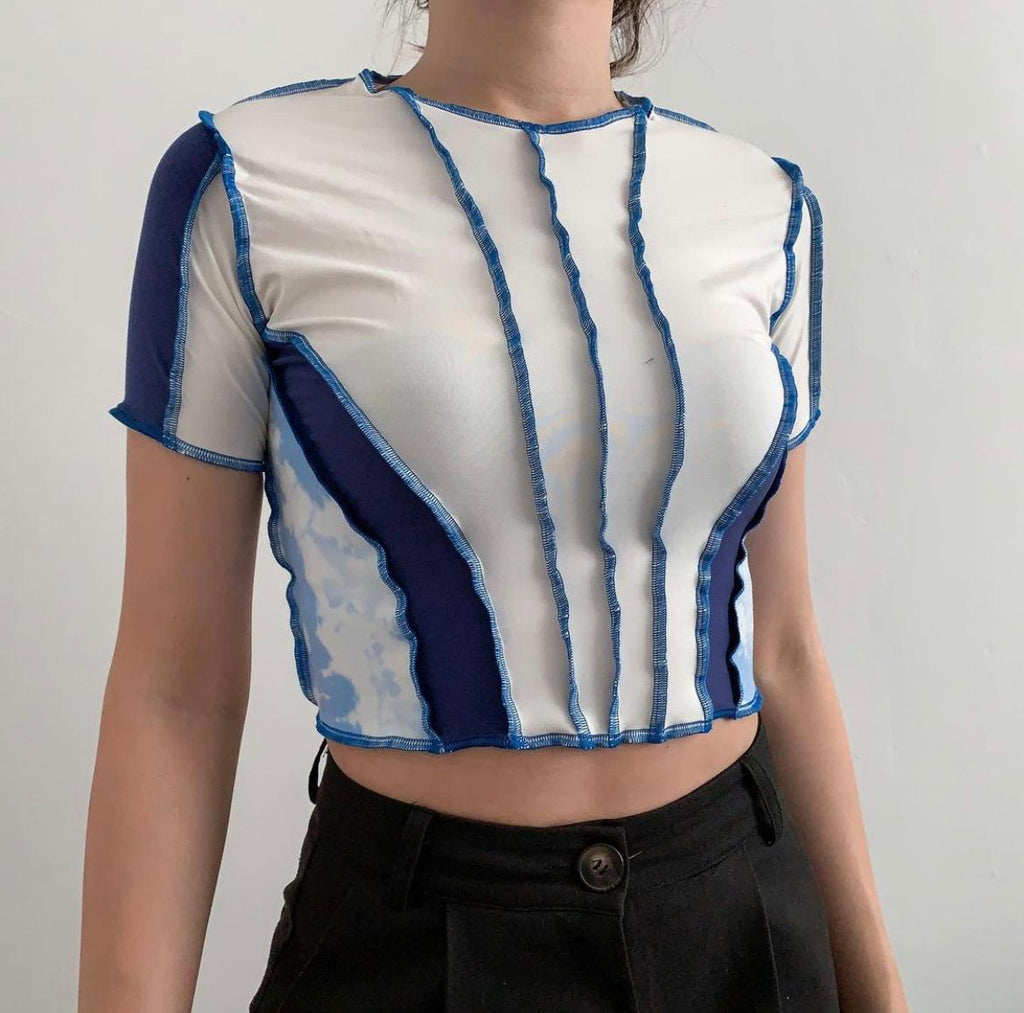 Strips of white fabric paired with dark blue and bleached blue fabric with cinched effect. Raw hem using dark blue thread