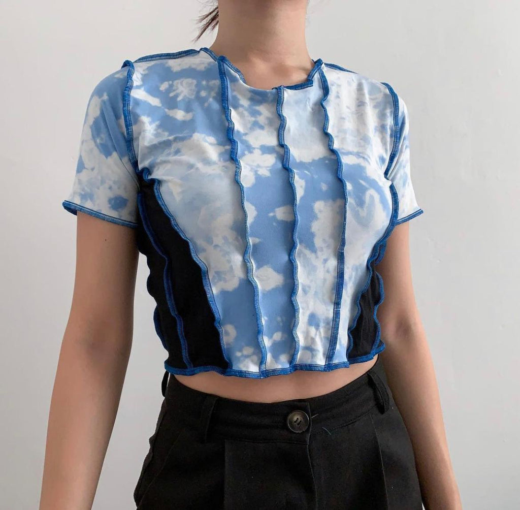 Bleached blue, cloudy effect top stitched together with black fabric at the sides, with blue thread. Raw hem