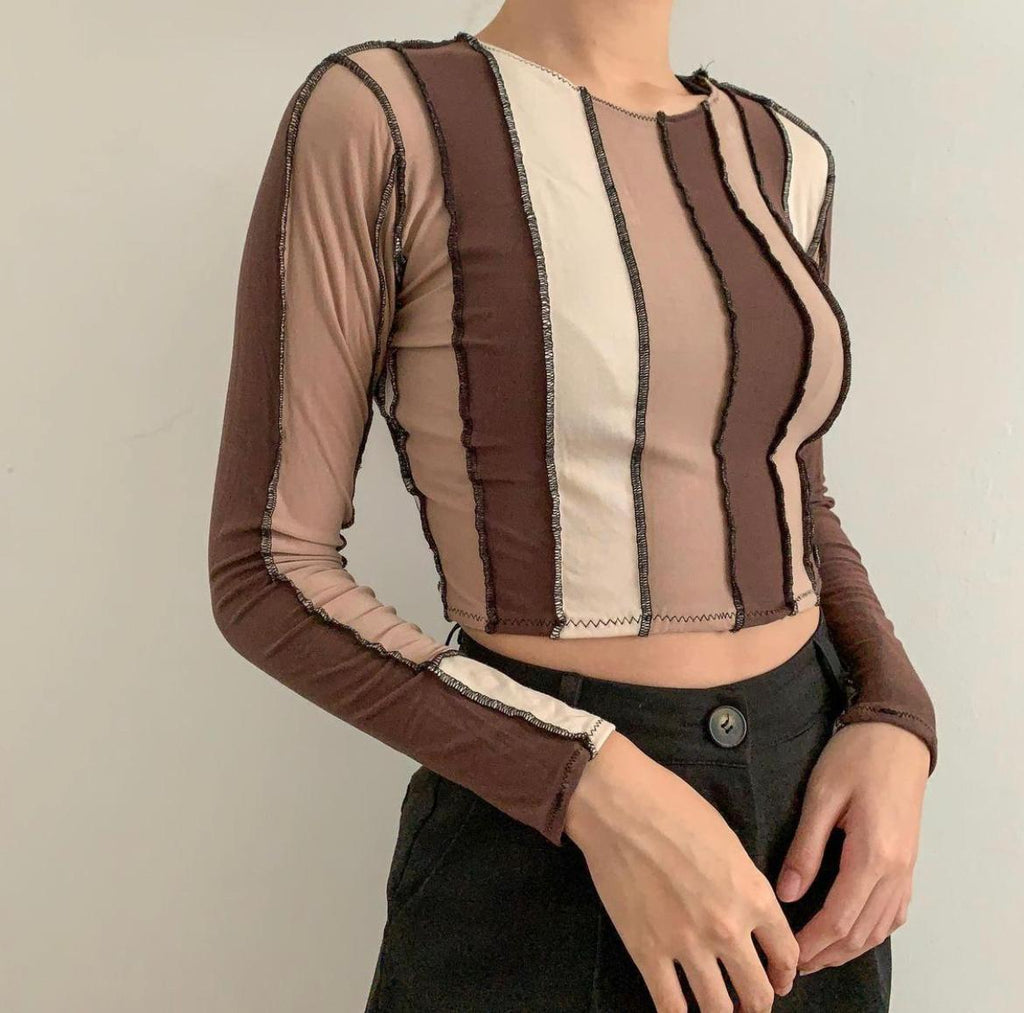 Strips of different shades of brown long sleeve top seen vertical down with a raw hem in black