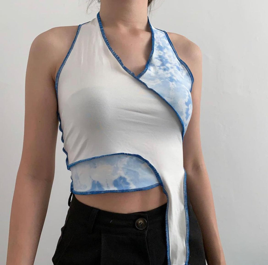 White and bleached blue fabric stitched together with a raw hem of bright blue turned into a halter top design 