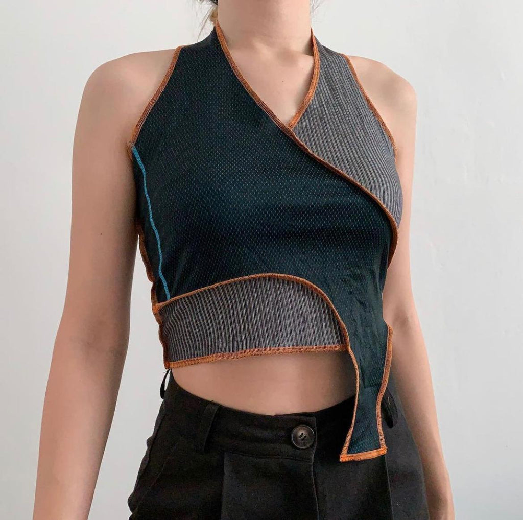 Dark green dri fit stitched together with a corduroy textured fabric, halter top. Raw hem using orange thread 